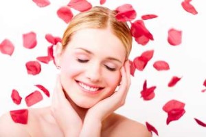 Beautiful girl surrounded by rose petals - best anti aging